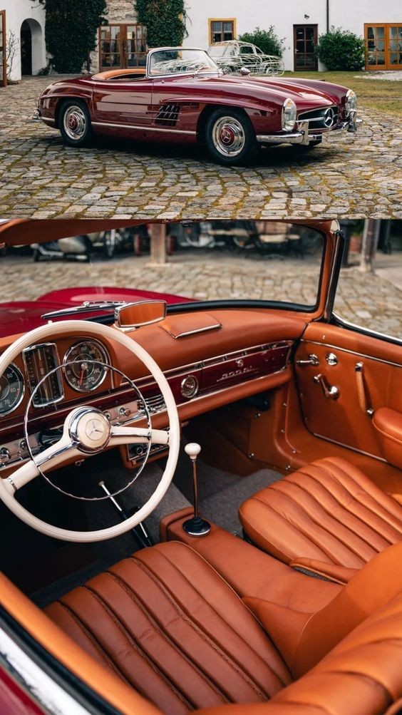 Vintage red convertible with tan leather interior parked on cobblestone driveway.