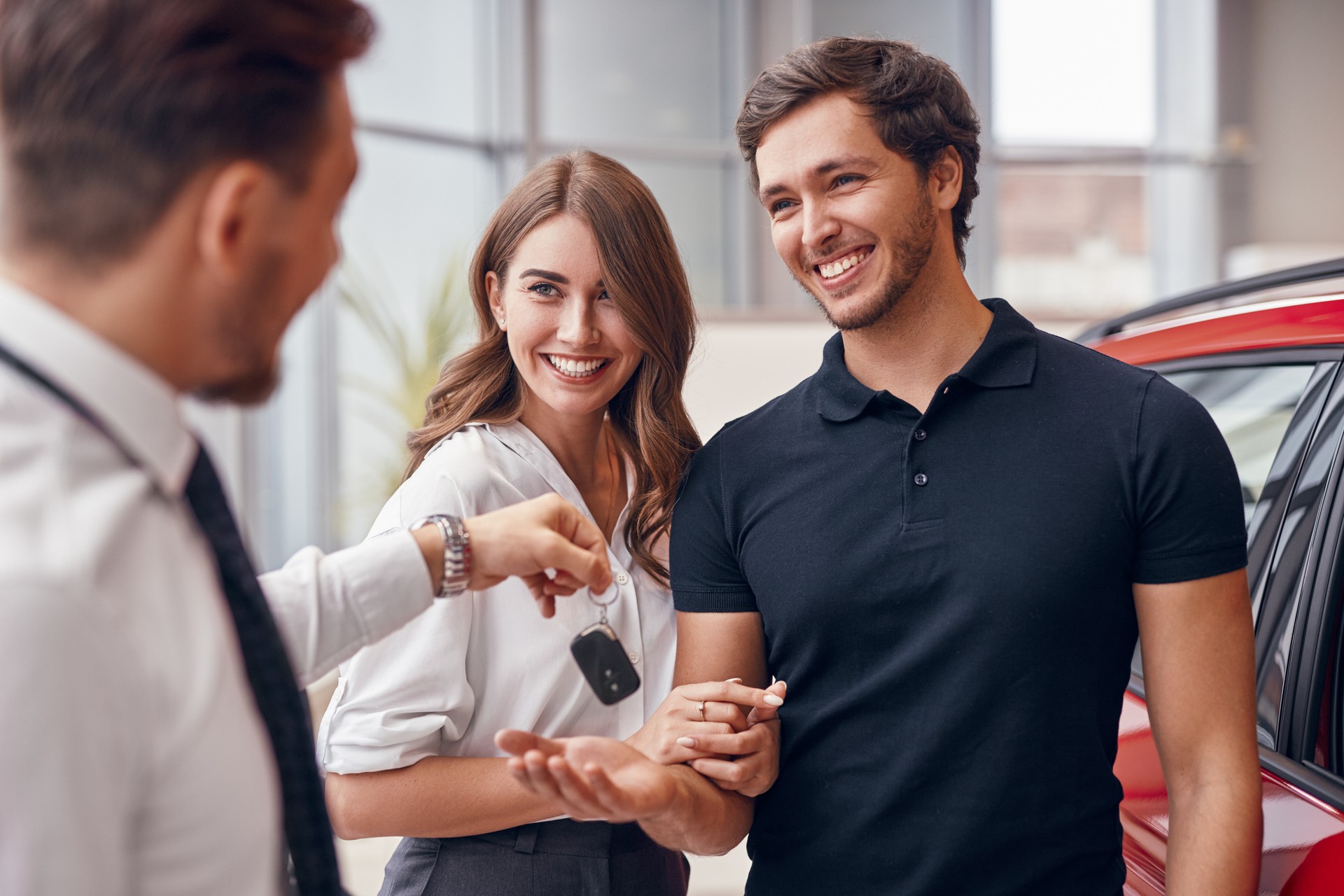 Cheerful couple buying car in modern salon