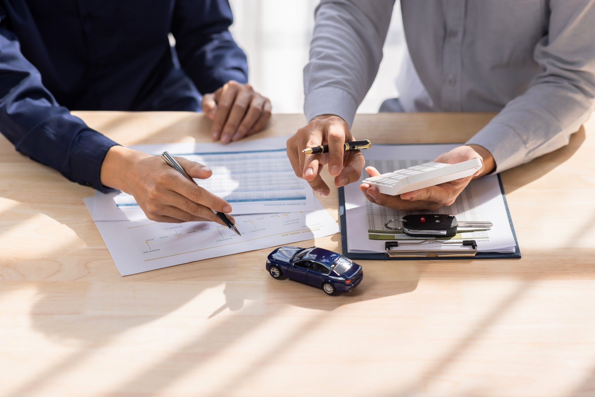 Dealer salesman giving car key to owner. client signing insurance document or rental car lease form agreement contract Insurance car concept.